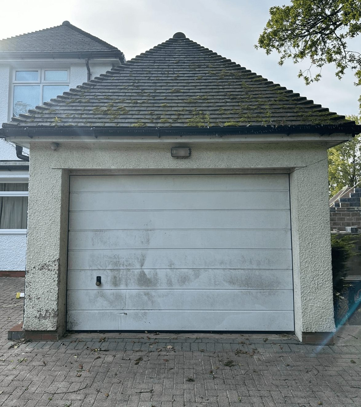 Before photo of a white garage door that is going to get sprayed
