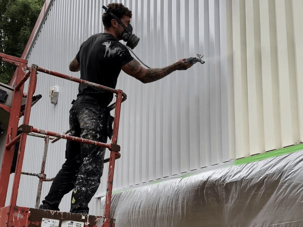 One of our professional paint sprayers coating a warehouse